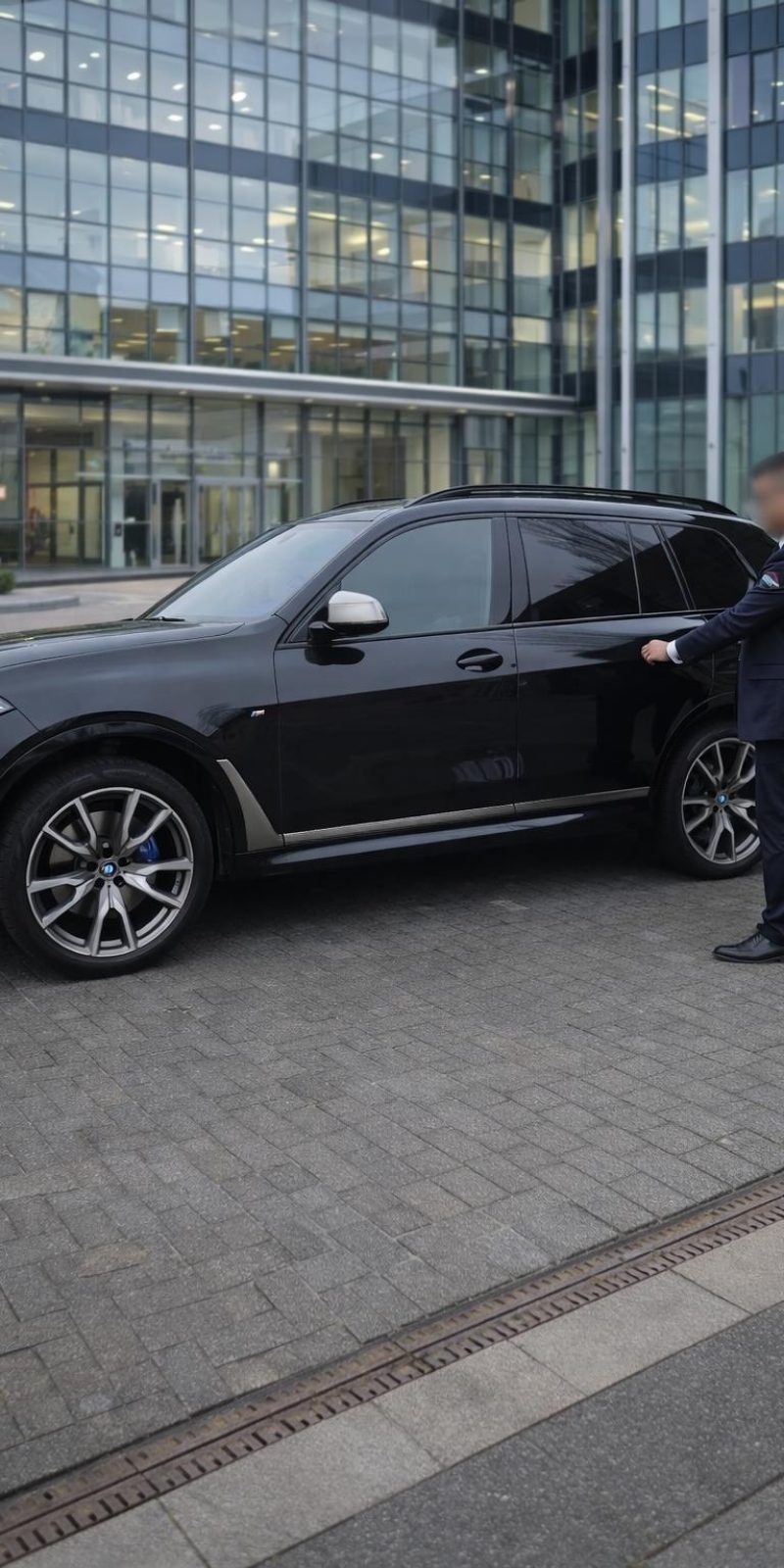 Beveiliger van Dutch Allround Security bij een auto voor een kantoorgebouw
